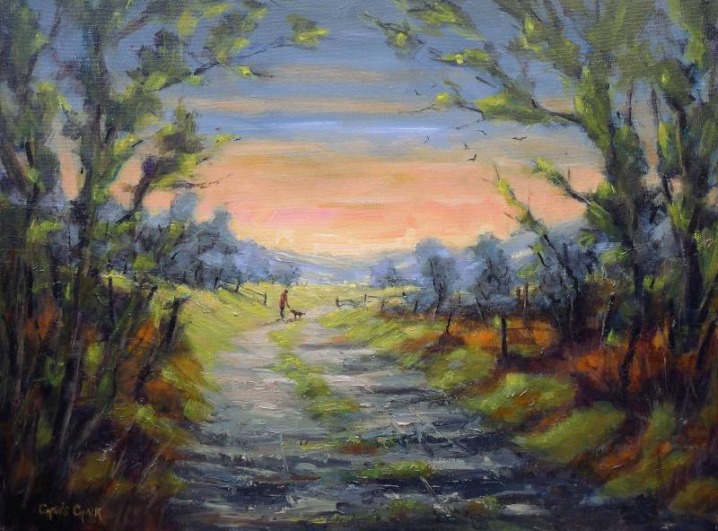 A oil painting of a sunset seen through the trees of a woodland with a man and his dog going for a walk